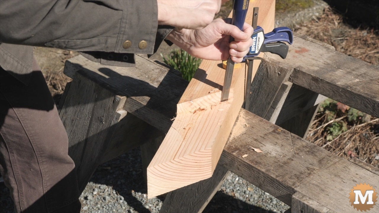 Using a chisel and mallet on a wooden corner brace