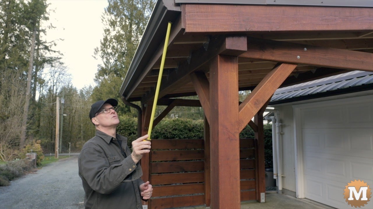 a man measuring a roof