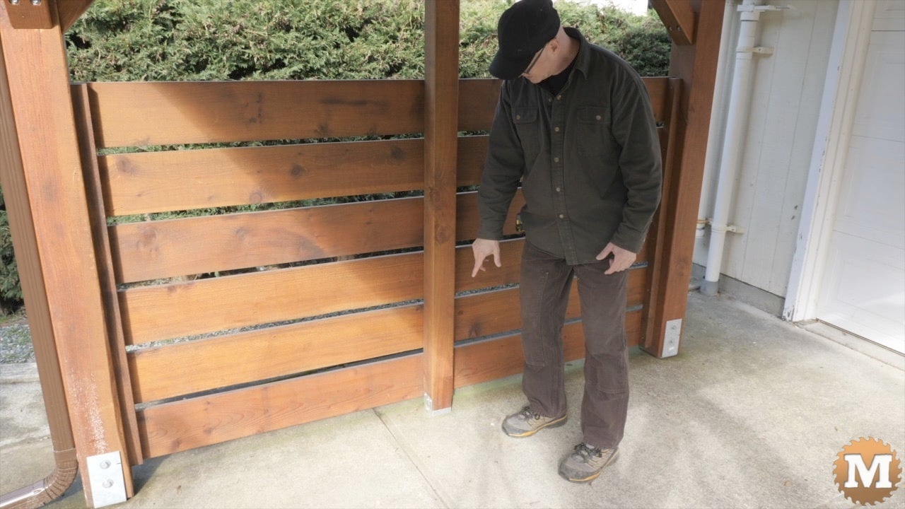 a man standing in front of a wooden wall