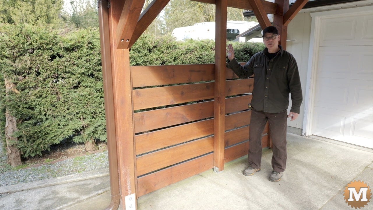 a man standing in front of a wooden structure