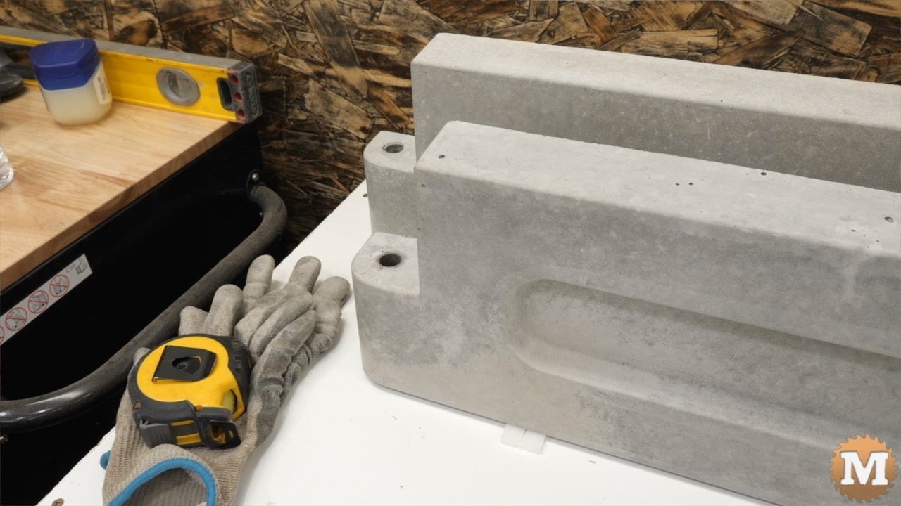close image of two concrete castings and some tools on a table