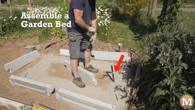 A man assembling a concrete garden bed