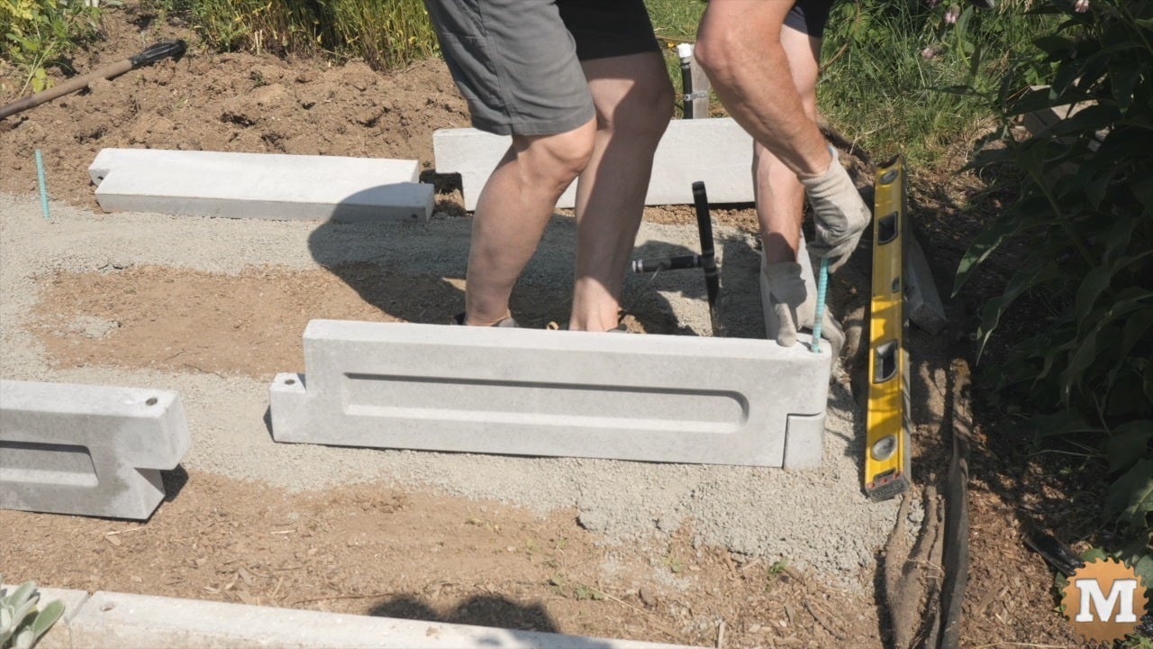 A man assembling a concrete garden bed