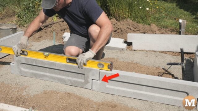 A man assembling a concrete garden bed