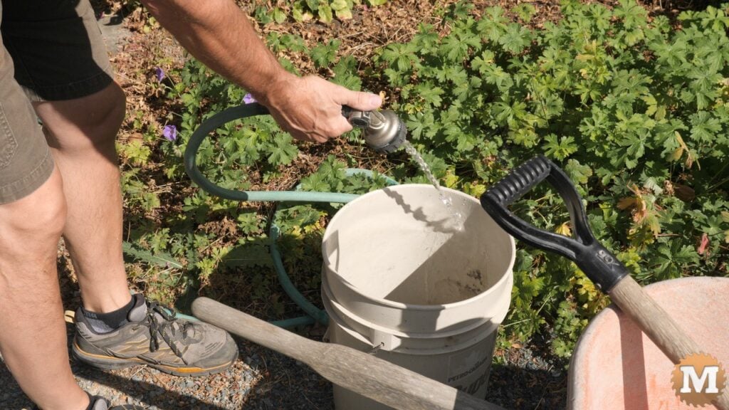 a man holding a garden hose