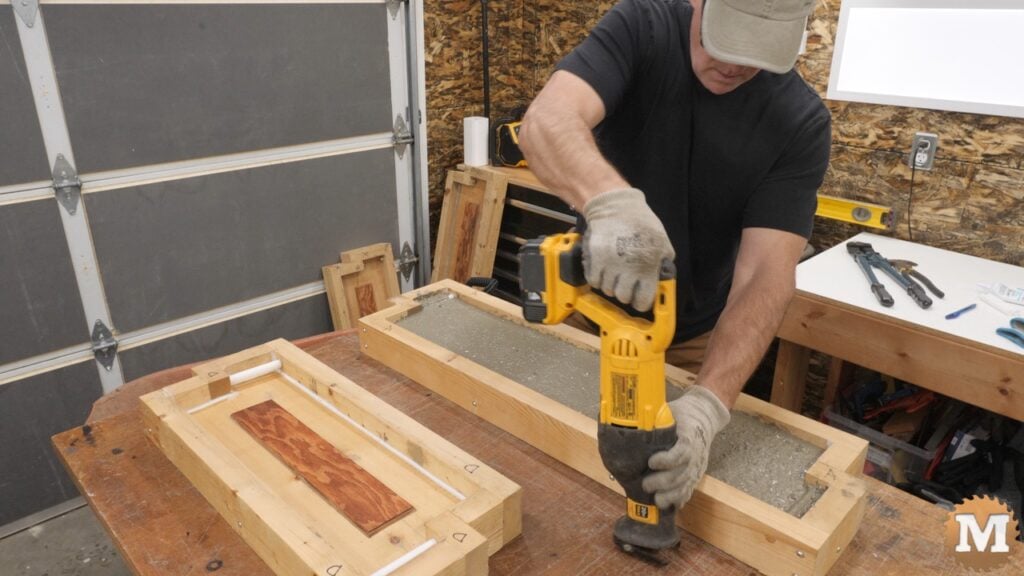 a man holding a reciprocating saw to vibrate a concrete pour