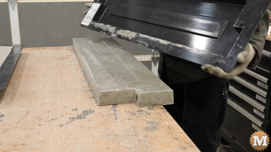 a cast concrete panel being unmolded on a workbench