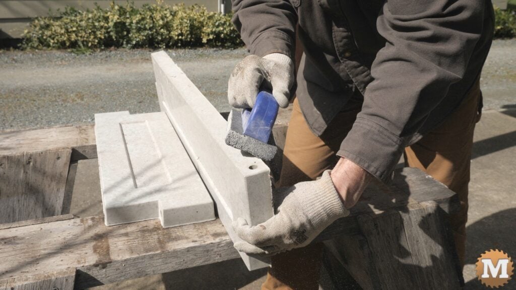 a man smoothing rough concrete edge with tool