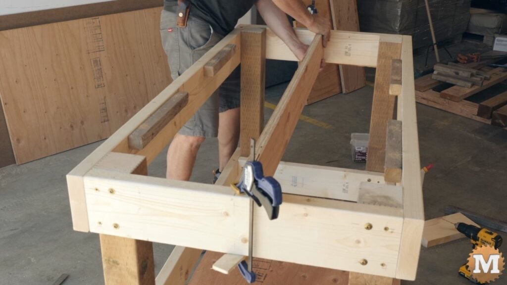 a man attaching a plywood brace to workbench aprons