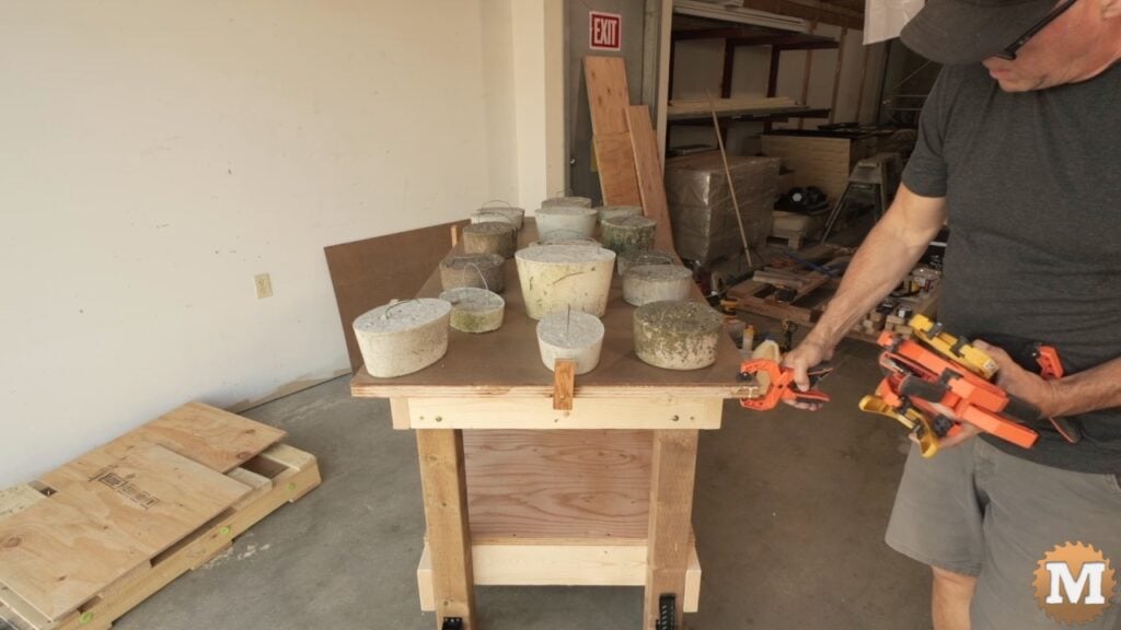 man attaching clamps to the top edge of a workbench