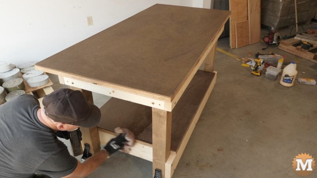 man applying finish to workbench with a rag
