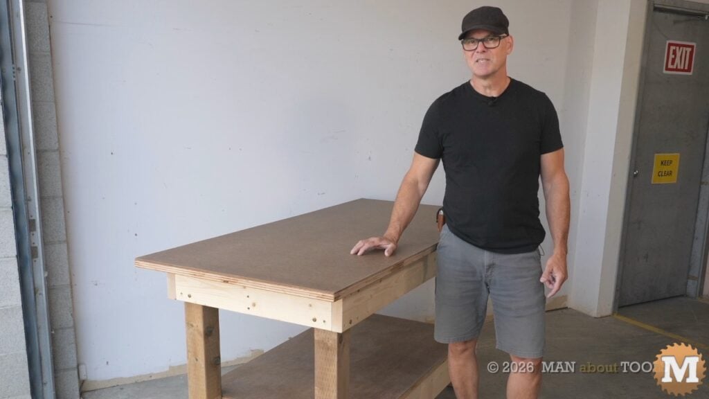 man standing beside a diy workbench