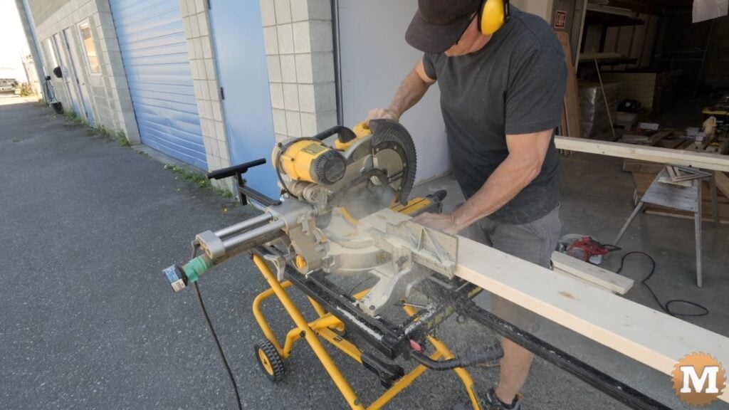 a man cutting wood with a miter saw